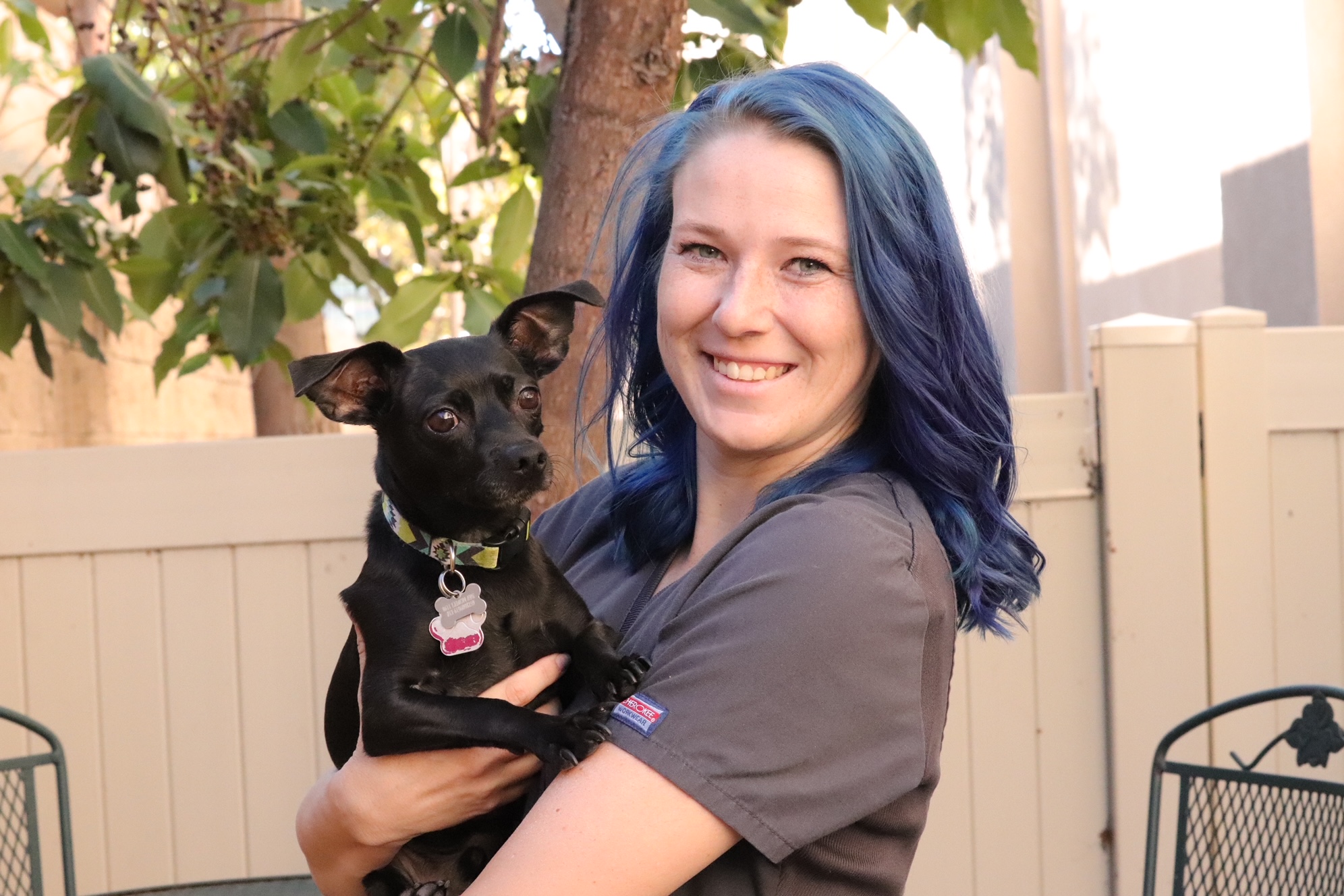 female with blue hair and small black dog